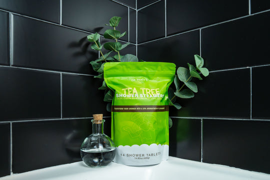 Aromatic tea tree shower steamers set against a backdrop of soft towels, designed to deliver a spa-like experience with every use.